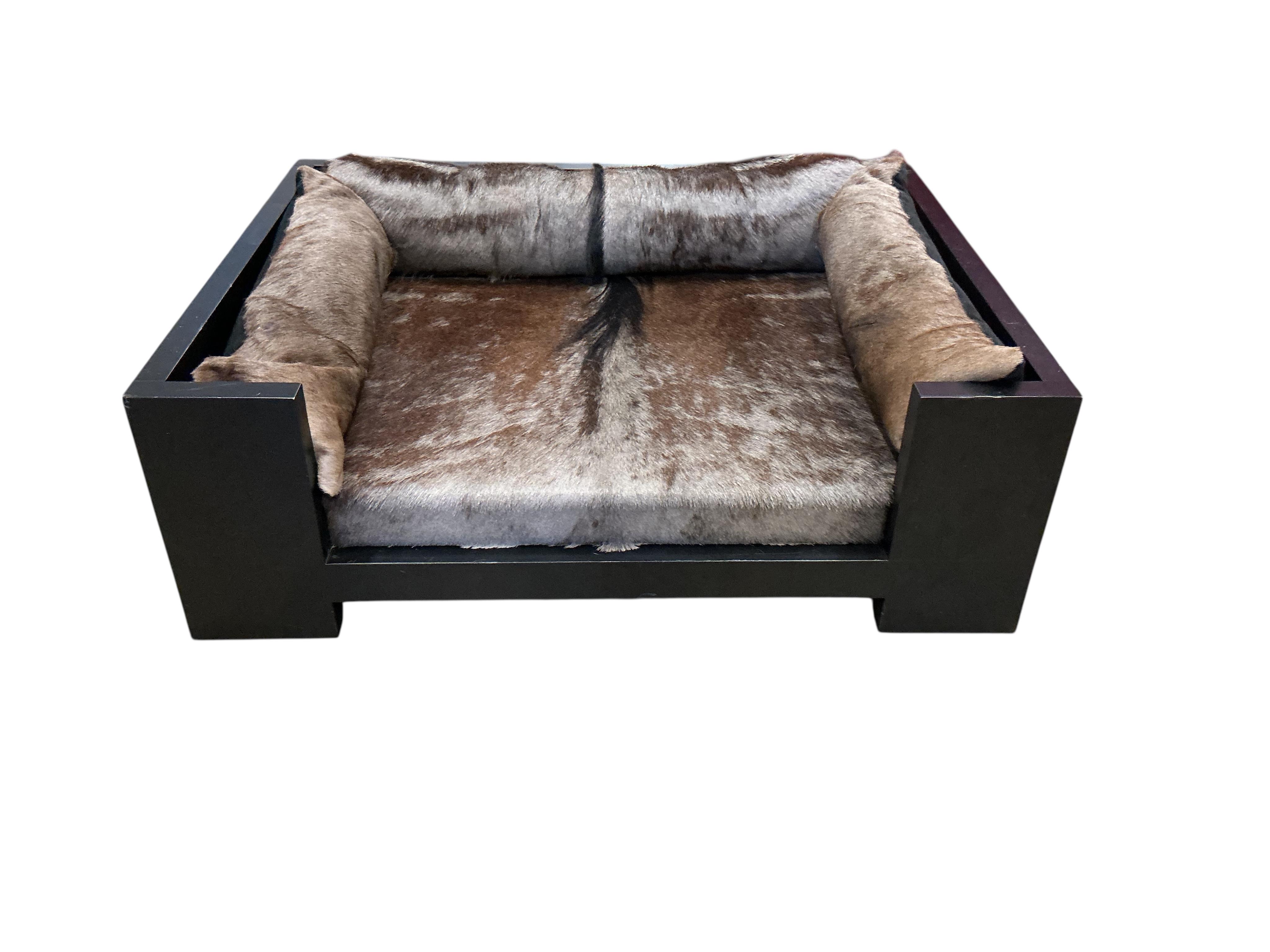 A contemporary ebonised dog bed with faux fur cushions, width 87cm, depth 67cm, height 29cm